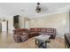 Living room with tile floors featuring a large brown leather couch, coffee table, and staircase at 12013 Whistling Wind Dr, Riverview, FL 33579