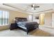 A spacious main bedroom with a tray ceiling, and a dark wood bedroom set and two windows at 12013 Whistling Wind Dr, Riverview, FL 33579