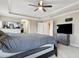 Bright main bedroom featuring a ceiling fan, TV, and an ensuite bathroom entrance at 12013 Whistling Wind Dr, Riverview, FL 33579
