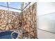 Enclosed pool area with stone walls and a glass enclosure at 1940 72Nd Ne Ave, St Petersburg, FL 33702