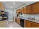 Open concept kitchen with wood cabinets, granite countertops and black appliances at 19807 Gulf Blvd # 128, Indian Shores, FL 33785