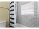 Clean bathroom with a shower/tub combo and black and white striped shower curtain at 19807 Gulf Blvd # 128, Indian Shores, FL 33785