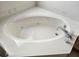 Corner bathtub with jets and a marble surround at 2421 E Del Webb Blvd, Sun City Center, FL 33573