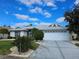 House exterior featuring a white garage door and lush landscaping at 2421 E Del Webb Blvd, Sun City Center, FL 33573