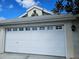 White two-car garage with decorative accents at 2421 E Del Webb Blvd, Sun City Center, FL 33573