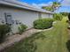 Side yard with landscaping, showcasing a neatly trimmed bush at 2421 E Del Webb Blvd, Sun City Center, FL 33573