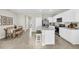 Open concept kitchen with island, white cabinets and stainless steel appliances at 2460 Mellow Ln, Clearwater, FL 33765