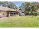 Spacious backyard with grassy lawn and screened enclosure at 2582 Bentley Dr, Palm Harbor, FL 34684