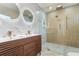 A modern bathroom featuring double sinks, unique lighting, and a luxurious glass-enclosed shower with gold hardware at 3612 W Leila Ave, Tampa, FL 33611