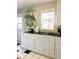 Efficient kitchen with white cabinets, black countertops, and a pot rack at 5407 29Th S Ave, Gulfport, FL 33707