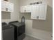 Laundry room with washer, dryer, and ample cabinet storage at 16910 Trite Bend St, Wimauma, FL 33598