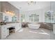 Luxurious bathroom with soaking tub, double vanity, and marble tile at 3073 Woodsong Ln, Clearwater, FL 33761