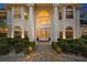 Elegant home exterior at night, featuring a grand entrance and landscape lighting at 3073 Woodsong Ln, Clearwater, FL 33761