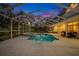 Inviting screened pool and spa with patio furniture at dusk at 3073 Woodsong Ln, Clearwater, FL 33761
