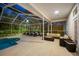 Relaxing screened patio with fire pit and lounge chairs near the pool at 3073 Woodsong Ln, Clearwater, FL 33761