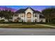 Impressive two-story home with a grand facade at dusk at 3073 Woodsong Ln, Clearwater, FL 33761