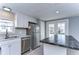 Modern kitchen with white shaker cabinets, stainless steel appliances and a large island at 39053 Flora Ave, Zephyrhills, FL 33542