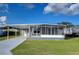 Single-wide mobile home with carport and screened porch at 39053 Flora Ave, Zephyrhills, FL 33542