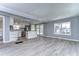 Open concept kitchen and living area with stainless steel appliances and grey vinyl flooring at 39053 Flora Ave, Zephyrhills, FL 33542
