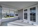 Bright screened porch, featuring double french doors and gray walls at 39053 Flora Ave, Zephyrhills, FL 33542