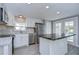 Modern kitchen with white shaker cabinets, stainless steel appliances, and a large island at 39053 Flora Ave, Zephyrhills, FL 33542