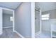 Grey hallway with vinyl flooring, leading to a bathroom with a glass shower at 39053 Flora Ave, Zephyrhills, FL 33542