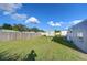 Large backyard with wooden fence, shed, and grassy area at 39053 Flora Ave, Zephyrhills, FL 33542