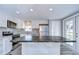 Modern kitchen with white shaker cabinets, stainless steel appliances, and a large island at 39053 Flora Ave, Zephyrhills, FL 33542