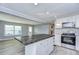 Modern kitchen with white shaker cabinets, stainless steel appliances, and a large island at 39053 Flora Ave, Zephyrhills, FL 33542