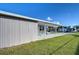 Gray manufactured home with covered porch and well-manicured lawn at 39053 Flora Ave, Zephyrhills, FL 33542