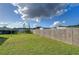 Large backyard with wooden fence and grassy area at 39053 Flora Ave, Zephyrhills, FL 33542
