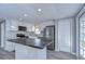 Modern kitchen with white shaker cabinets, stainless steel appliances, and a large island at 39053 Flora Ave, Zephyrhills, FL 33542
