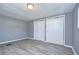 Simple bedroom with gray walls, wood-look floors, and double door closets at 39053 Flora Ave, Zephyrhills, FL 33542
