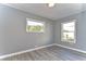 Gray walls, wood-look floors, and windows offer a bright bedroom at 39053 Flora Ave, Zephyrhills, FL 33542