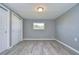 Well-lit bedroom with gray walls, wood-look floors, and double door closets at 39053 Flora Ave, Zephyrhills, FL 33542
