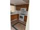 Galley kitchen with wood cabinets and white appliances at 6345 Newtown Cir # 45A3, Tampa, FL 33615