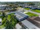 An aerial shot showcases the home's gray roof, well-maintained lawn, and proximity to a quiet residential street at 6701 13Th N Ave, St Petersburg, FL 33710