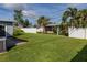 Expansive backyard with a well-kept lawn, framed by a privacy fence and mature landscaping at 6701 13Th N Ave, St Petersburg, FL 33710