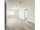 Spacious living room with expansive windows and new wood-look flooring for a light, airy atmosphere at 6701 13Th N Ave, St Petersburg, FL 33710