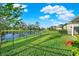 Landscaped backyard with a pond view and metal fence at 10715 High Noon Trl, Parrish, FL 34219