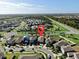 Suburban homes dot the landscape in this aerial shot, showcasing a community near wooded areas and a prominent highway at 16912 Yellow Pine St, Wimauma, FL 33598