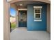Welcoming front porch featuring a dark front door and blue accent wall at 16912 Yellow Pine St, Wimauma, FL 33598