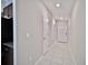 Bright hallway with tile flooring, neutral walls, and white doors at 16912 Yellow Pine St, Wimauma, FL 33598