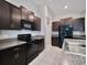 Well-equipped kitchen with granite countertops, dark cabinetry, and stainless steel appliances at 16912 Yellow Pine St, Wimauma, FL 33598
