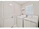 Bright laundry room with white washer and dryer at 16912 Yellow Pine St, Wimauma, FL 33598