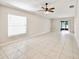 Bright living room features tile floors, ceiling fan, and sliding door to the porch at 16912 Yellow Pine St, Wimauma, FL 33598