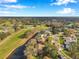 Aerial view of homes, a golf course, and mature trees, on a clear, sunny day at 390 Cypress Creek Cir, Oldsmar, FL 34677