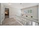 Bright upstairs hallway with white railing and wood floor at 390 Cypress Creek Cir, Oldsmar, FL 34677