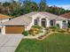 One-story home with brown garage door, landscaped yard, and walkway at 4080 Gevalia Dr, Brooksville, FL 34604