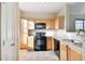 Well-lit kitchen featuring black appliances and wood cabinets at 5000 Culbreath Key Way # 7-701, Tampa, FL 33611